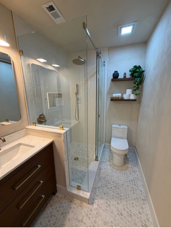 Renovated English basement bathroom with glass shower and mineral-finish walls