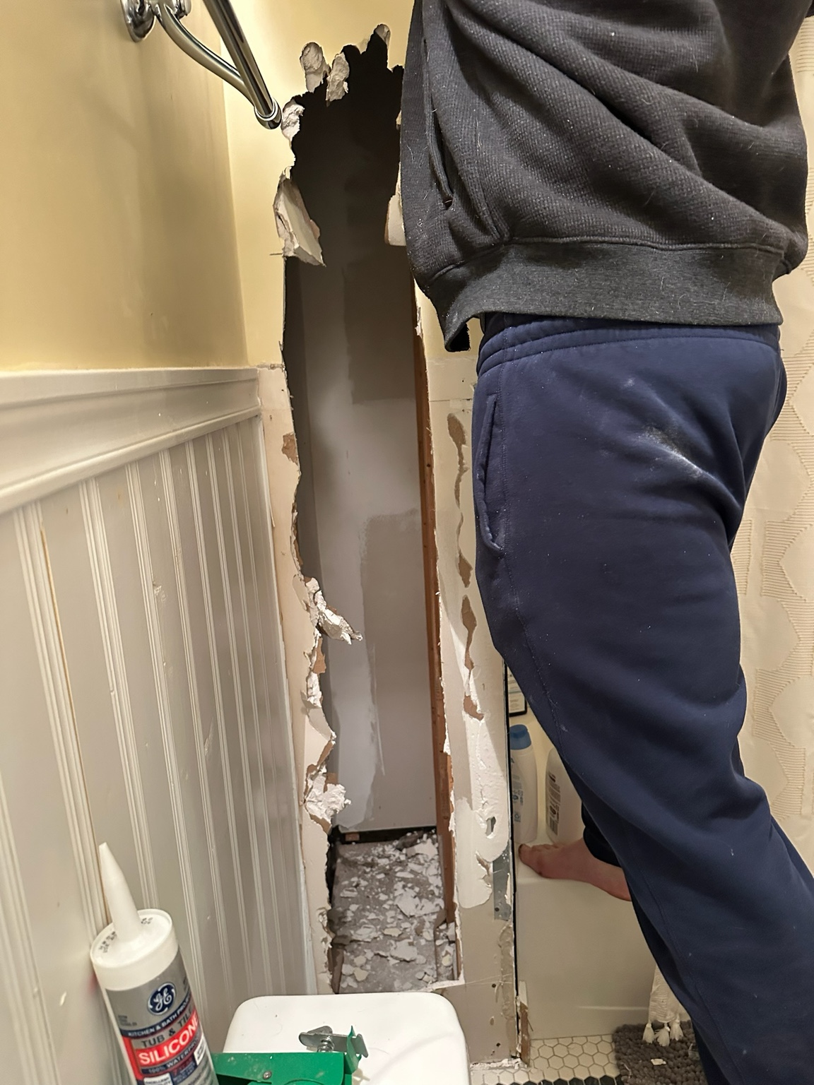 Drywall being removed beside the upstairs shower after finding an empty wall cavity