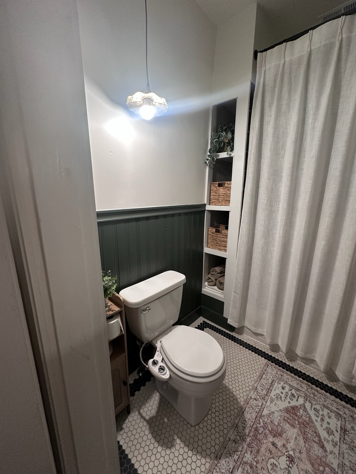 Finished recessed shelves beside the shower holding baskets and folded towels