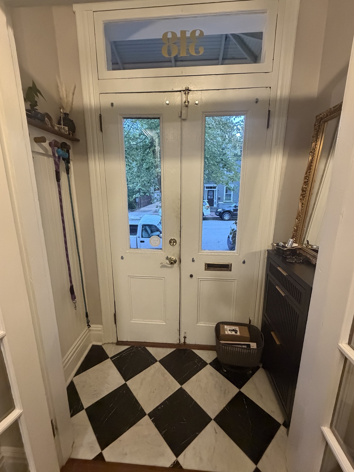 The completed front vestibule with marble floor, dog leash wall, shoe cabinet, and gold mirror
