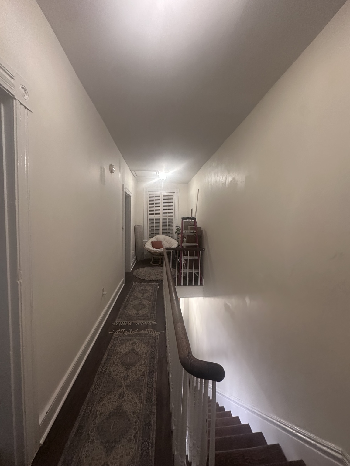 A piece of molding being bent to follow the uneven upstairs hallway wall